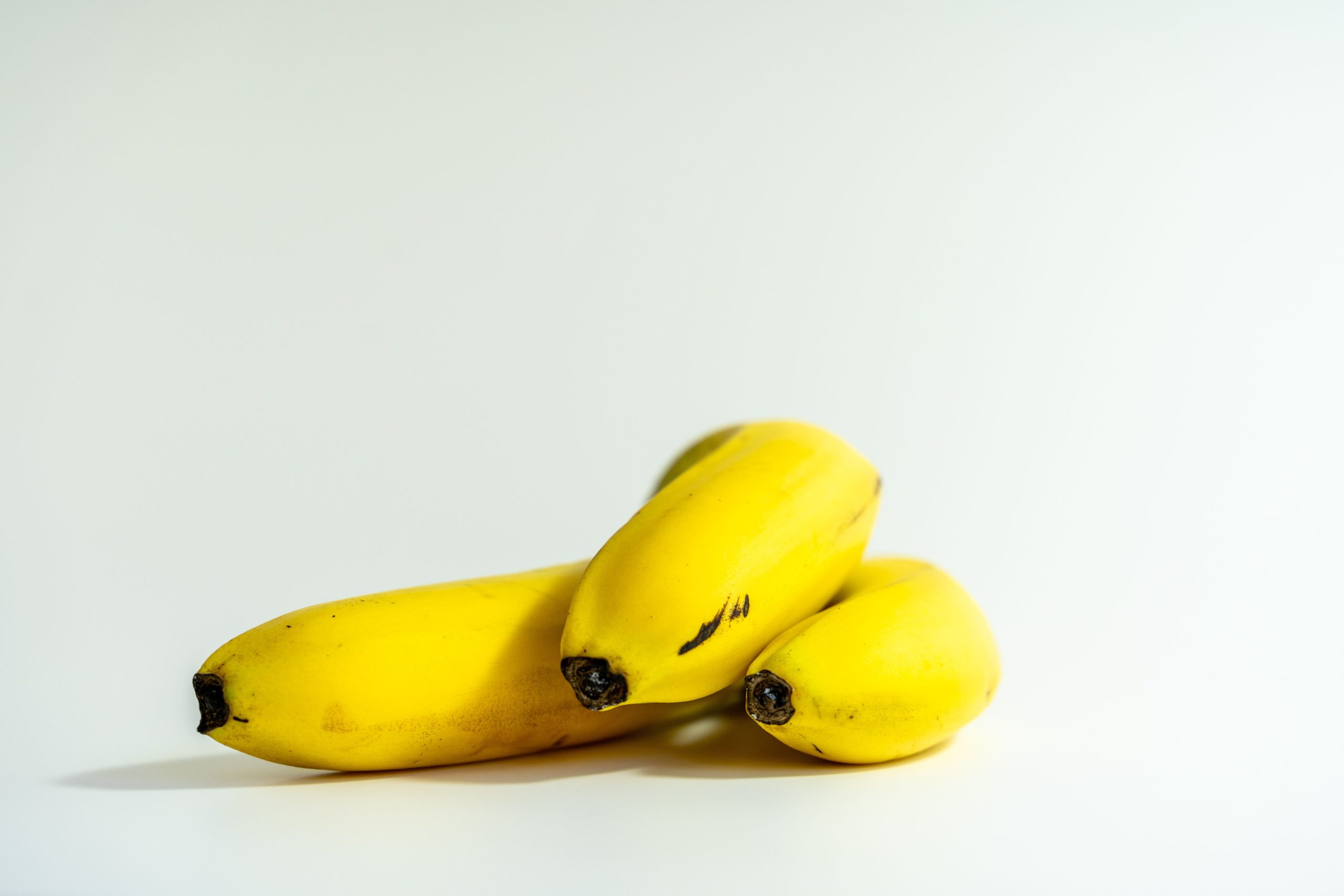 Vibrant yellow bananas in a minimalist studio shot perfect for healthy lifestyle themes.