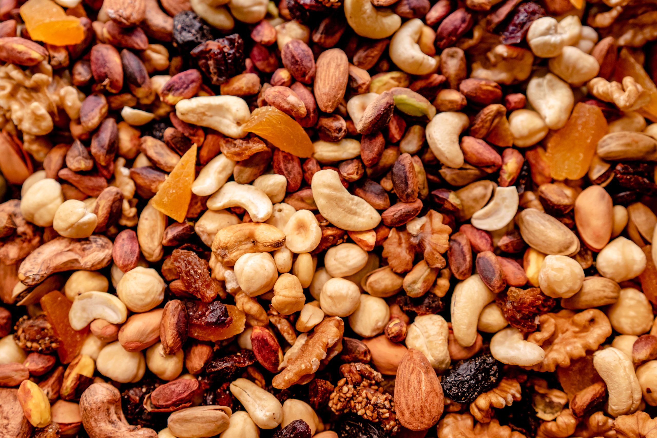 Close-up of assorted nuts and dried fruits creating a colorful, nutritious mix.
