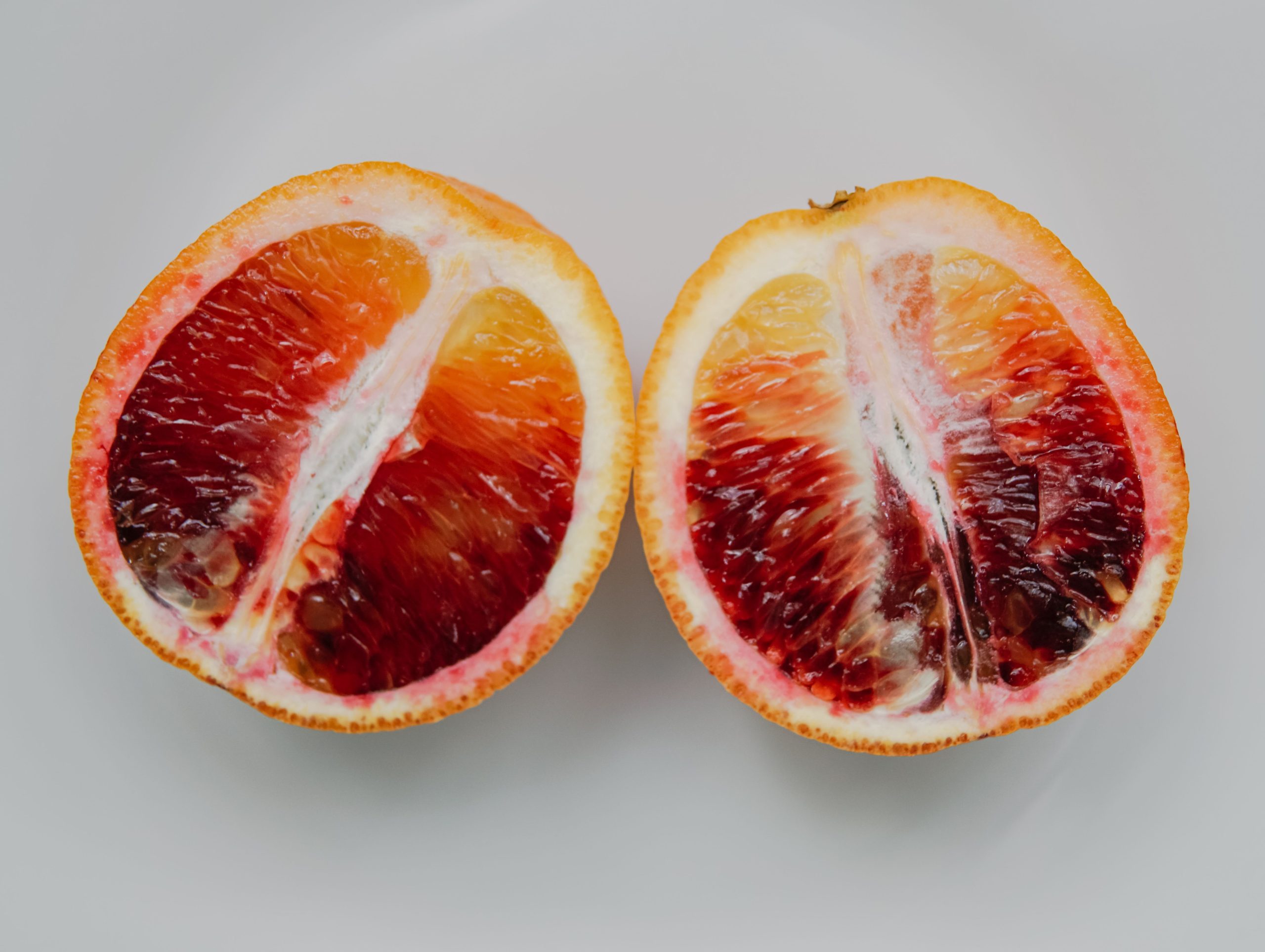 A fresh, juicy blood orange sliced in half showcasing its vibrant colors and textures.